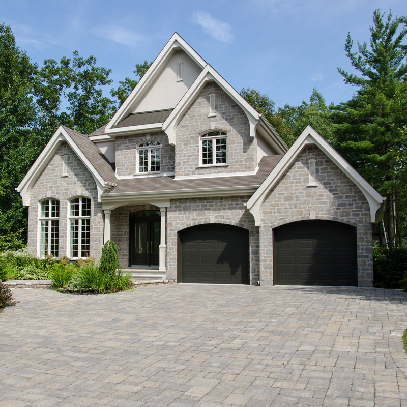 a stone house with garage doors